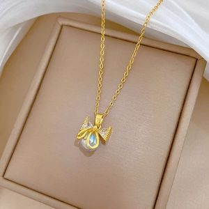 Elegant gold bow necklace with pearl and crystals in a jewelry box