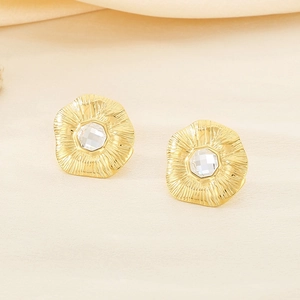 Dettaglio macro di orecchini a fiore a ventaglio in oro 18K con cristallo chiaro