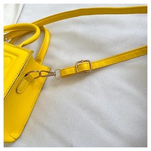 Détail du sac à main en cuir PU jaune montrant la boucle et la fixation de la poignée