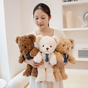 Three plush teddy bears in brown and beige with blue ties held by a model