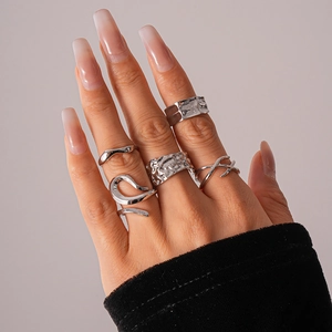 Detail of silver five-piece ring set featuring irregular geometric textures on a hand