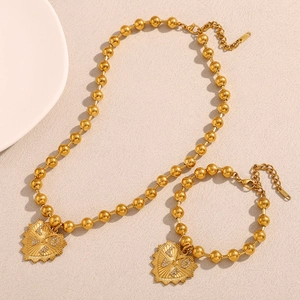Dettaglio del set collana e bracciale a sfere placcate oro 18K con ciondolo a cuore LOVE