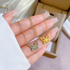 Collane con ciondolo a farfalla minimaliste in finiture oro e argento mostrate sulla mano