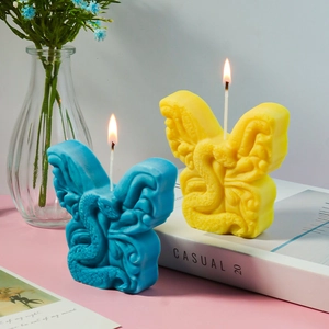 Dettaglio di candele a farfalla con motivo a serpente giallo e blu in ambiente casalingo