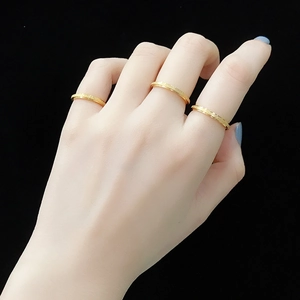 Close-up of three 2mm golden frosted stainless steel rings on a female hand
