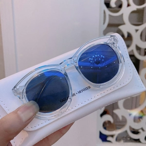 Detail of kids sunglasses with transparent frames, blue lenses and white leather case