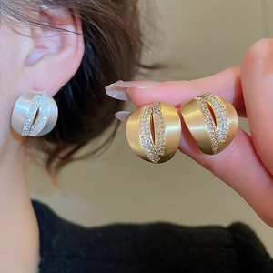 Macro detail of brushed C-shape stud earrings with rows of sparkling zircon stones