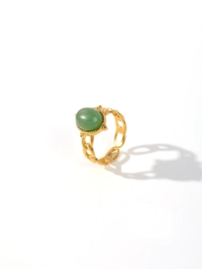 Detail of vintage 18k gold plated ring featuring green oval malachite and chain band