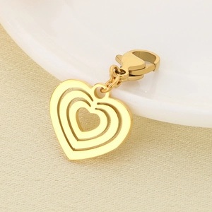 Close-up of golden hollow heart pendant with lobster clasp on a beige textured background