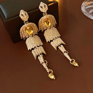 Detailed view of vintage gold tassel earrings with yellow teardrop crystals and pearls