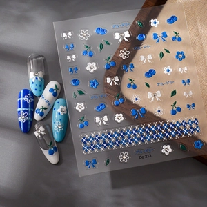 Detail of blue bow and blueberry nail stickers with Co-213 grid patterns for DIY manicure