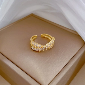 Adjustable gold plated crisscross ring with sparkling zircons on a jewelry display