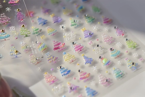 Detailed macro view of 3D Christmas tree nail stickers with sparkling crystal rhinestones