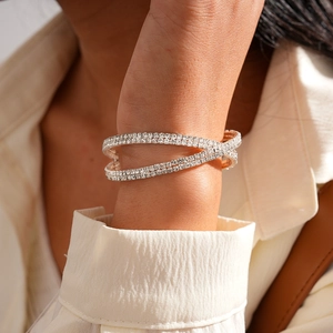 Close-up of rose gold double-layer crisscross bangle with sparkling pave zircon stones