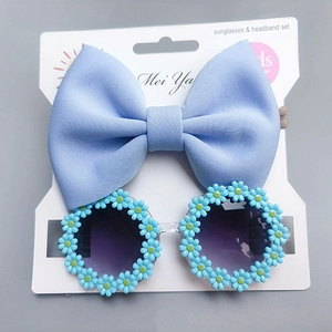 Detail of light blue bow headband and daisy flower sunglasses set for toddlers