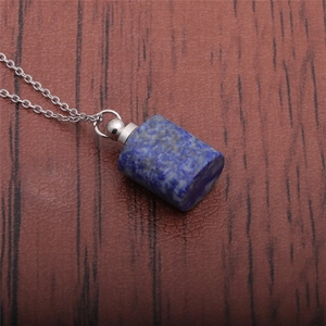 Close-up of cylindrical lapis lazuli perfume bottle pendant on a silver metal chain