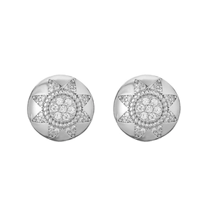Detail of silver sunburst earrings with central zircon inlay and vintage star pattern texture