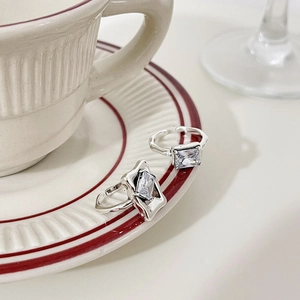 Minimalist 925 silver open ring featuring a rectangular zircon on a ceramic cup saucer