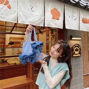 Close-up of blue plaid canvas tote bag with two large dark blue bows in Japanese style