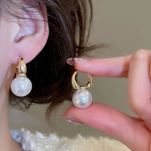 Detailed close-up of French vintage round pearl earrings with elegant gold hoop clips
