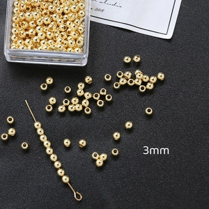 Vista macro de cuentas de cobre chapadas en oro de 3 mm para joyería artesanal DIY