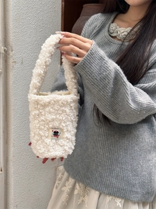 Close-up of fluffy white plush water bottle carrier bag with cute cat patch detail