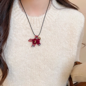 Dettaglio della collana con ciondolo a orsetto floccato rosso e fiocco a quadri