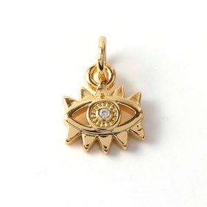 Macro shot of gold-plated evil eye charm with shimmering zircon and radiant lash detail