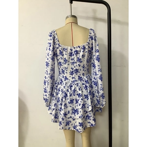 Detail of blue floral dress featuring a square neck and ruffled layered hemline
