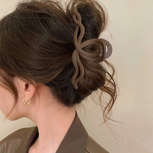 Vista dettagliata di un fermaglio per capelli ondulato opaco marrone per chignon.