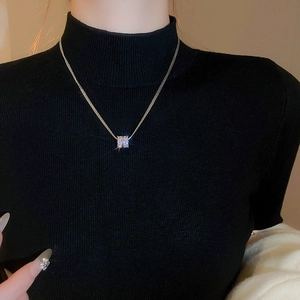 Detailed close-up of a silver multilayer necklace featuring a zircon encrusted round pendant