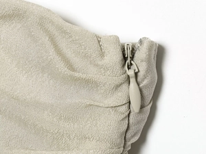 Close-up of champagne chiffon fabric showing the invisible zipper detail and fine texture