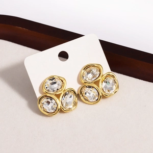 Dettaglio di orecchini geometrici placcati in oro con cluster di cristalli di zircone