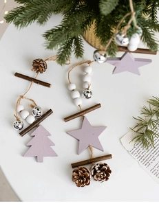 Detail of Nordic wooden Christmas wind chimes with purple stars and pine cones