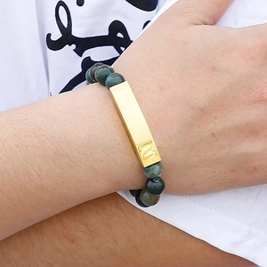 Deep green natural stone bead bracelet with gold rectangular metal charm on model wrist