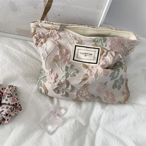 Gros plan du tissu jacquard floral avec fermeture éclair et étiquette Pleasant Time sur la pochette