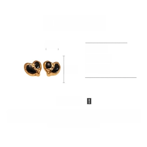 Detail view of heart-shaped stainless steel earrings with black enamel and gold plating