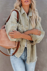 Detail of frayed fringe hem and vintage denim texture on a long sleeve jacket