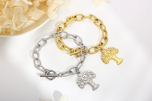 Detail of gold and silver heart tree charm bracelets with toggle clasp on white background