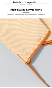 Detail view of beige canvas fabric texture with tan leather trim and golden metal rivet