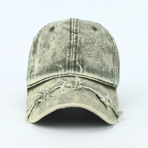 Close-up of distressed washed denim baseball cap featuring vintage frayed edges and holes