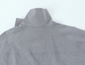 Gros plan détaillé du col de chemise en popeline à petits carreaux gris et blancs