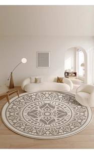 Detail of round mandala woven rug in beige and brown tones on light wood floor