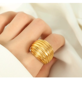 Dettaglio dell'anello largo placcato oro 18K con trama a righe su tessuto neutro
