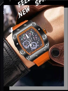 Primer plano de un reloj mecánico de tonel con correa de silicona naranja y esfera calada
