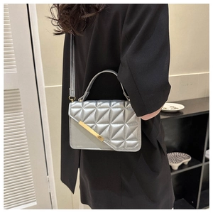 Dettaglio della borsa a tracolla argento trapuntata con elegante inserto in metallo dorato