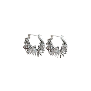 Irregular silver thorn hoop earrings in minimalist punk style on white background