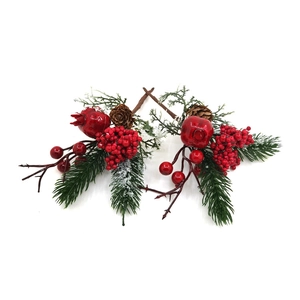 Dettaglio di bacche rosse, pigne e aghi innevati per decorazioni natalizie classiche