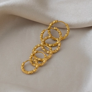 Three pairs of gold stainless steel hoop earrings with textured diamond-cut finish