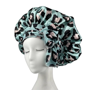 Detail of mint green leopard print satin sleep bonnet on a white mannequin head
